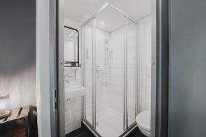 a bathroom with a shower and a toilet at No8 Boutique Hotel - self check in in Unterseen