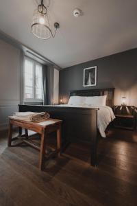 a bedroom with a large bed and a wooden table at No8 Boutique Hotel - self check in in Unterseen