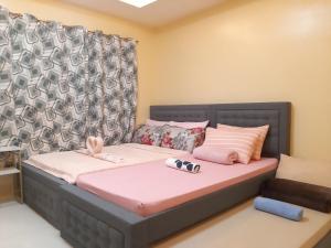 1 dormitorio con cama con sábanas rosas y almohadas rosas en Aussie Inn Baguio City Direct en Baguio