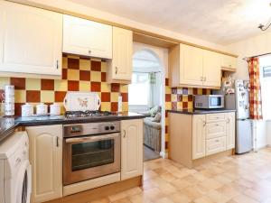 a kitchen with white cabinets and a stove top oven at 21 Crossways in Clacton-on-Sea