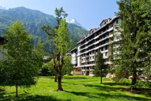 un gran edificio de apartamentos en un parque con árboles en Apartment Chamois Blanc 2, en Chamonix-Mont-Blanc