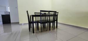 a black table and chairs sitting on a tiled floor at Bertam Homestay Kepala Batas in Kepala Batas +4 photos