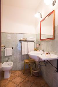a bathroom with a sink and a toilet and a mirror at Hotel Lido degli Spagnoli Wellness & Spa in Portoscuso