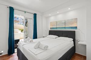 Sitio de CalahondaにあるBeachfront Calahonda apartmentのベッドルーム(青いカーテン付きの白い大型ベッド1台付)