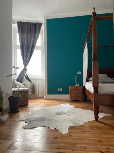 1 dormitorio con cama y pared azul en 100qm Altbau Wohnung im Prenzlauer Berg, en Berlín