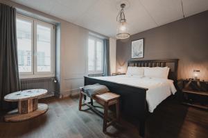 una camera da letto con un letto grande e un tavolo di No8 Boutique Hotel - self check in a Unterseen