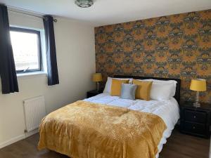 um quarto com uma cama grande e um cobertor amarelo em River view Apartment em Glasgow