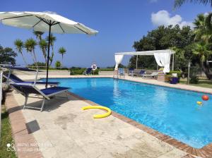 卡帕乔-帕埃斯图姆Chalet vista Capri的游泳池旁的椅子和遮阳伞