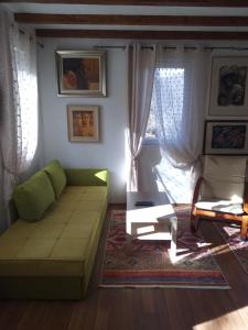 a living room with a green couch and a table at Restuarant-Apartments T'ga za jug Lazaropole in Lazaropole