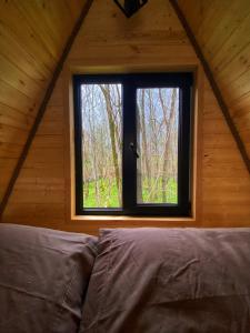 ein Schlafzimmer mit einem Fenster in einer Holzhütte in der Unterkunft Cottage Villa Ioseliani in Kumistavi
