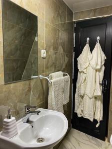 ein Badezimmer mit einem Waschbecken, einem Spiegel und Handtüchern in der Unterkunft Cottage Villa Ioseliani in Kumistavi