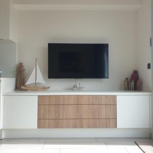 a flat screen tv on a white wall at Appartement, residentie Syci in Koksijde