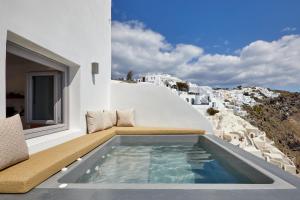 a swimming pool on the balcony of a house at Allure Breeze Suites in Oia