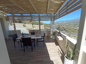 a patio with a table and chairs on a balcony at Evdion Galini in Galini