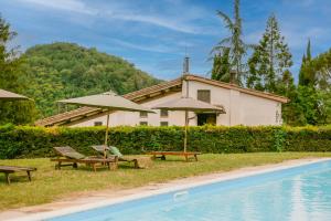 een huis met stoelen en parasols naast een zwembad bij Tenuta delle Rose - Country House in Piane