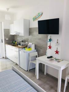 a kitchen with white cabinets and a white table at Case vacanze I trabocchi in San Vito Chietino