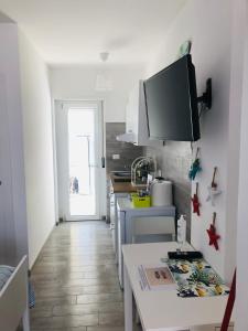 a kitchen with a table and a tv on the wall at Case vacanze I trabocchi in San Vito Chietino
