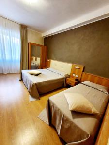 um quarto de hotel com duas camas e uma janela em Hotel Corallo em La Spezia