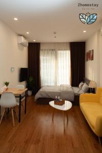 un salon avec un canapé et une table dans l'établissement Vinhomes Smartcity-Căn hộ dich vụ -Zhomestay, à Phú Thú