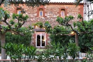 a brick building with trees in front of it at La maison des vendangeurs in Canet-en-Roussillon