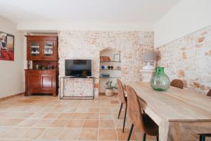a living room with a wooden table and a tv at Conte Orsini Apartment in Conversano