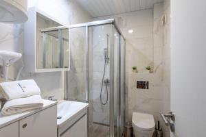 uma casa de banho branca com um chuveiro e um WC. em Velika Recepcija 3 em Palisat