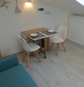 a dining room with a table and two chairs at Monolocale mansarda a Porto Santo Stefano Argentario in Porto Santo Stefano