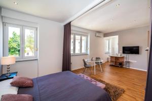 Schlafzimmer mit einem Bett, einem Tisch und einem TV in der Unterkunft Studio Apartment Jader in Zadar