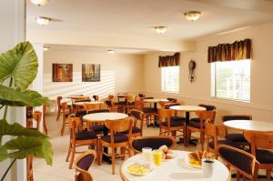 un restaurante con mesas y sillas en una habitación en Whispering Hills Inn en Branson