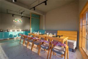 uma sala de jantar com uma mesa longa e cadeiras em Viable Inn by Vista Stays em Mukteshwar