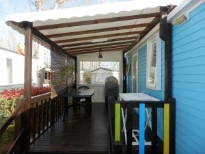 a patio with awning and a table on a house at Camping Les Sables du Midi in Valras-Plage