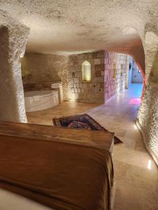 a room with a bath tub in a stone wall at Elite Cave Suites in Göreme
