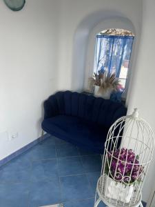 a living room with a blue couch and a window at Relais Villa Ettore in Ischia