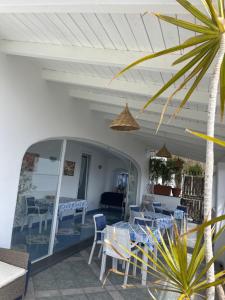 patio con tavolo e sedie sotto il portico di Relais Villa Ettore a Ischia