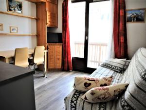 ein Wohnzimmer mit einem Sofa und einem Esstisch in der Unterkunft Appartement Auris, 2 pièces, 3 personnes - FR-1-297-40 in Auris