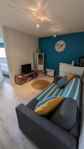 a living room with a couch and a clock on the wall at appartement T2 biscarosse plage in Biscarrosse-Plage