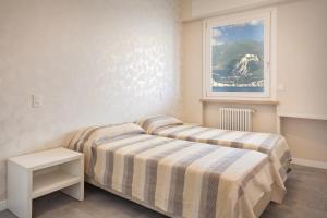 a bedroom with two beds and a window at Casa Giovanna - Vista al lago in Brenzone sul Garda