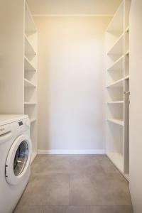 a laundry room with a washing machine and shelves at Casa Giovanna - Vista al lago in Brenzone sul Garda