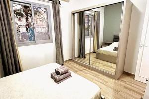 een slaapkamer met een spiegel en een bed met een tas bij Luxury Getaway /Brand New 2BR /Wi-Fi /Full Kitchen in Sharm El Sheikh