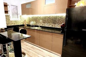 een keuken met een aanrecht en een zwarte koelkast bij Luxury Getaway /Brand New 2BR /Wi-Fi /Full Kitchen in Sharm El Sheikh