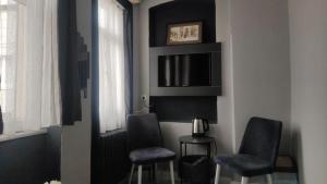イスタンブールにあるTaksim Hostel Green House Istanbulの椅子2脚、テーブル、窓が備わる客室です。