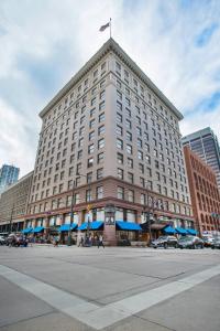 a large building with a flag on top of it at Magnolia Hotel Denver, a Tribute Portfolio Hotel in Denver