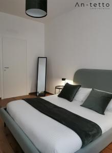 ein Schlafzimmer mit einem großen weißen Bett mit schwarzen Kissen in der Unterkunft An-tetto in Noto