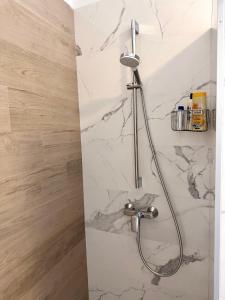 La salle de bains en marbre blanc est pourvue d'une douche. dans l'établissement Madonna Guesthouse II, à Dubrovnik