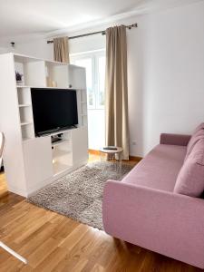 sala de estar con sofá púrpura y TV en Madonna Guesthouse II, en Dubrovnik