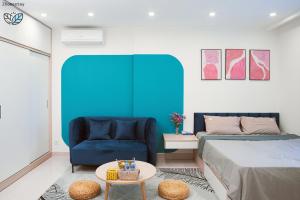 une chambre avec un lit et une chaise bleue dans l'établissement Vinhomes Smartcity-Căn hộ dich vụ -Zhomestay, à Thượng Thôn