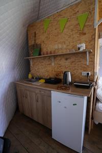 a small kitchen with a sink and a refrigerator at Ajara Glamping Kokotauri in Keda