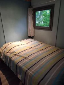 un letto in una camera da letto con finestra di Chalet 5 personnes vallée du lot a Laburgade