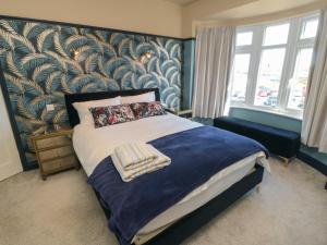 een slaapkamer met een bed met blauw en goud behang bij Driftwood House in Redcar