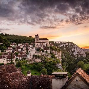 una città in cima a una montagna al tramonto di Chalet 5 personnes vallée du lot a Laburgade Altre 17 foto